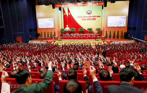  Các đại biểu biểu quyết, thông qua Nghị quyết Đại hội XIII Đảng Cộng sản Việt Nam. (Ảnh: TTXVN).