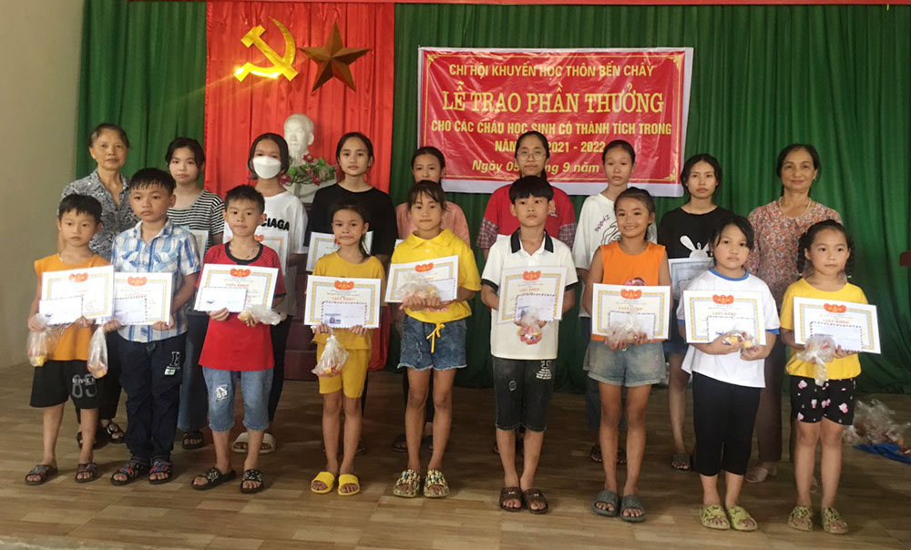  Bà Nguyễn Thị Soạn (hàng sau, ngoài cùng bên trái) trao thưởng cho các cháu có thành tích học tập xuất sắc.