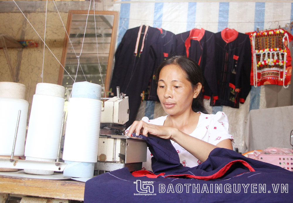  Chị Đinh Thị Ngọc Lương đang vắt sổ chiếc áo nam truyền thống của đồng bào dân tộc Dao.