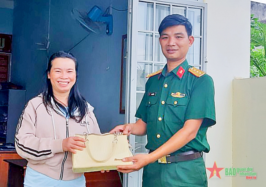  Thượng úy QNCN Bùi Xuân Tĩnh trả lại túi xách cho chị Phan Thị Chính (ảnh nhân vật cung cấp).