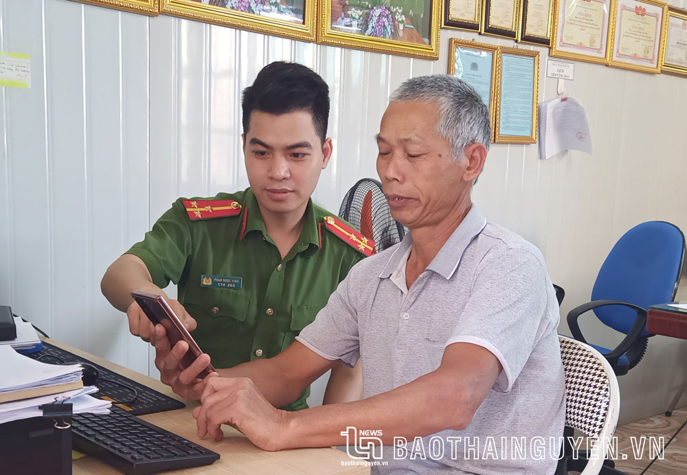 Công an thị trấn Hương Sơn hướng dẫn người dân theo dõi thông tin trên trang Fanpage của đơn vị.