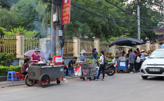 Khó kiểm soát an toàn vệ sinh thực phẩm tại các cơ sở kinh doanh thức ăn đường phố làm gia tăng nguy cơ ảnh hưởng tới sức khỏe người tiêu dùng. (chụp tại đường Z115, xã Quyết Thắng, đoạn phía trước cổng Trường Đại học Công nghệ Thông tin).