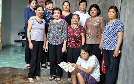  Bà Nguyễn Thị Huệ (đứng hàng trên, thứ hai từ trái sang) nhận giúp đỡ bà Nguyễn Thị Lý (người ngồi) 750 nghìn đồng/6 tháng.