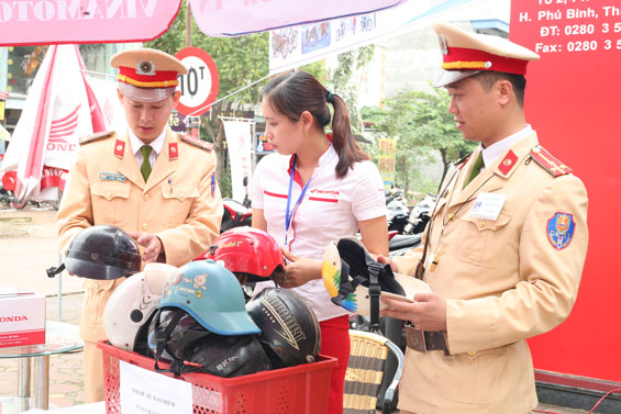   Các đồng chí trong Đội Cảnh sát giao thông huyện Phú Bình tuyên truyền với người dân về việc sử dụng mũ bảo hiểm kém chất lượng.