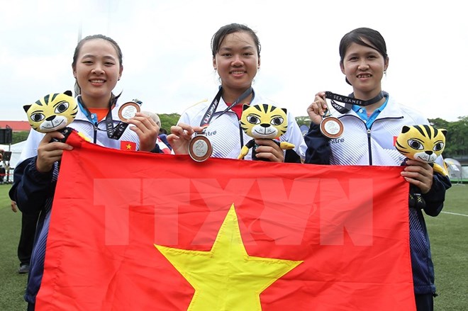  Đội bắn cung Việt Nam vui mừng với chiếc huy chương bạc. (Ảnh: TTXVN)