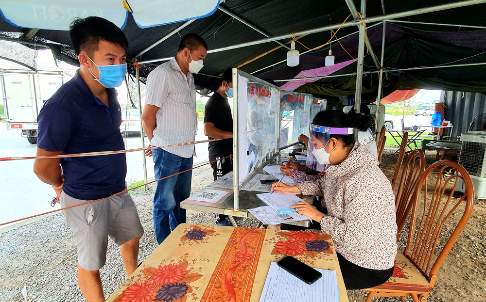  Chị Trần Thị Tằng, thành viên Ban Công tác Mặt trận xóm Hương Trung, xã Tân Hương (T.X Phổ Yên), hỗ trợ người dân khai báo y tế tại chốt kiểm soát liên ngành phòng, chống dịch COVID-19 nút giao Yên Bình.