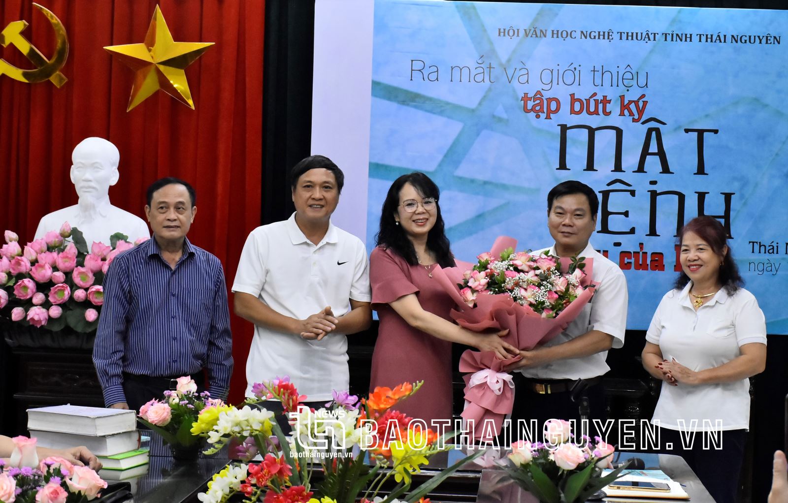 Lãnh đạo Hội Văn học nghệ thuật tỉnh tặng hoa cho đại diện các tác giả cuốn sách "Mật lệnh màu của lửa".