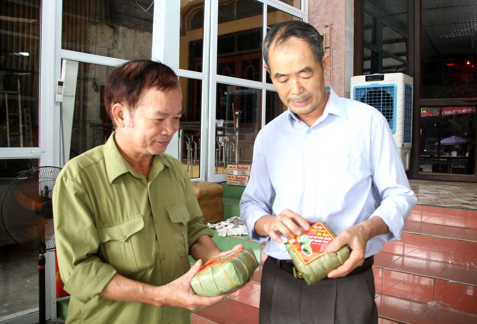 Ông Nguyễn Tiến Sỹ (bên phải) giới thiệu nhãn mác mới của HTX truyền thống bánh chưng Bờ Đậu do ông đứng ra thành lập tháng 6 vừa qua.