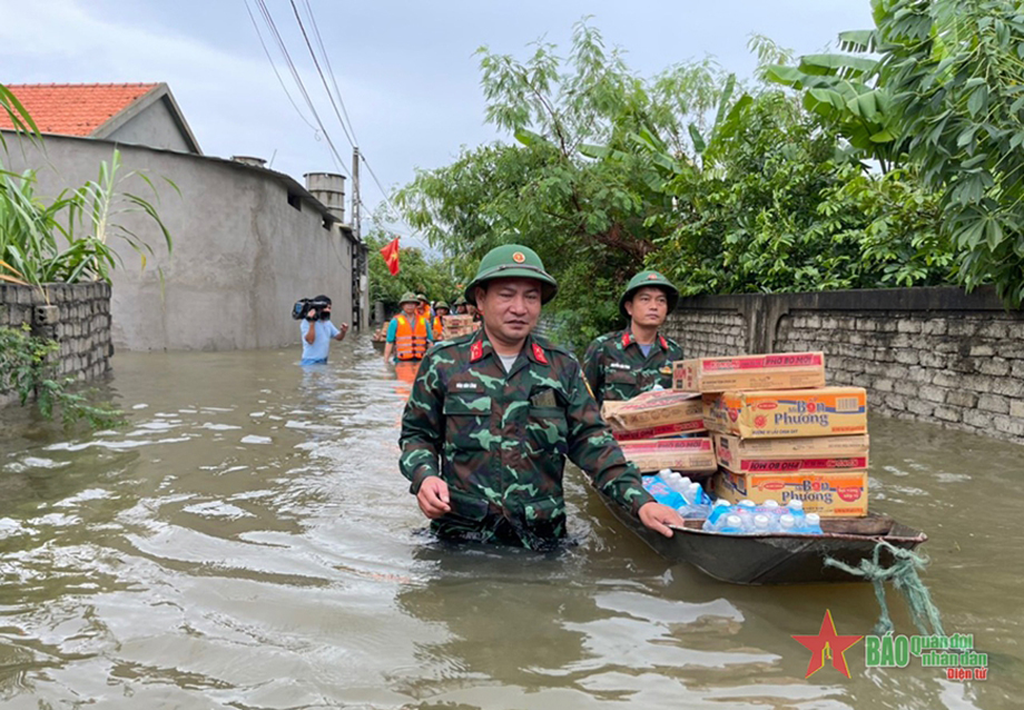 Ban CHQS huyện Quỳnh Lưu cứu trợ lương thực, nước uống cho các gia đình bị ngập lụt tại xã Quỳnh Diễn. Ảnh: ĐỨC VƯỢNG 