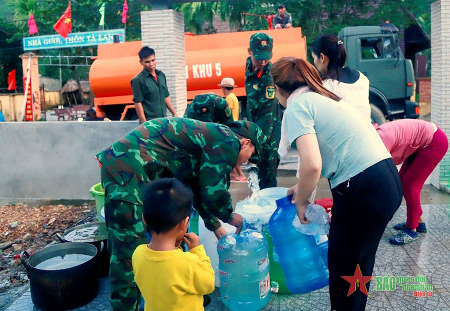  Bộ đội cấp nước vào các dụng cụ chứa nước của các hộ gia đình đồng bào Cơ Tu.