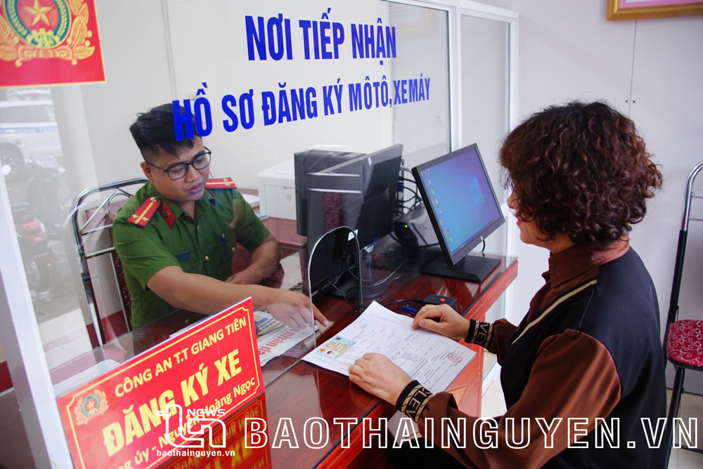  Cán bộ Công an thị trấn Giang Tiên (Phú Lương) tiếp nhận hồ sơ đăng ký biển số xe của công dân.