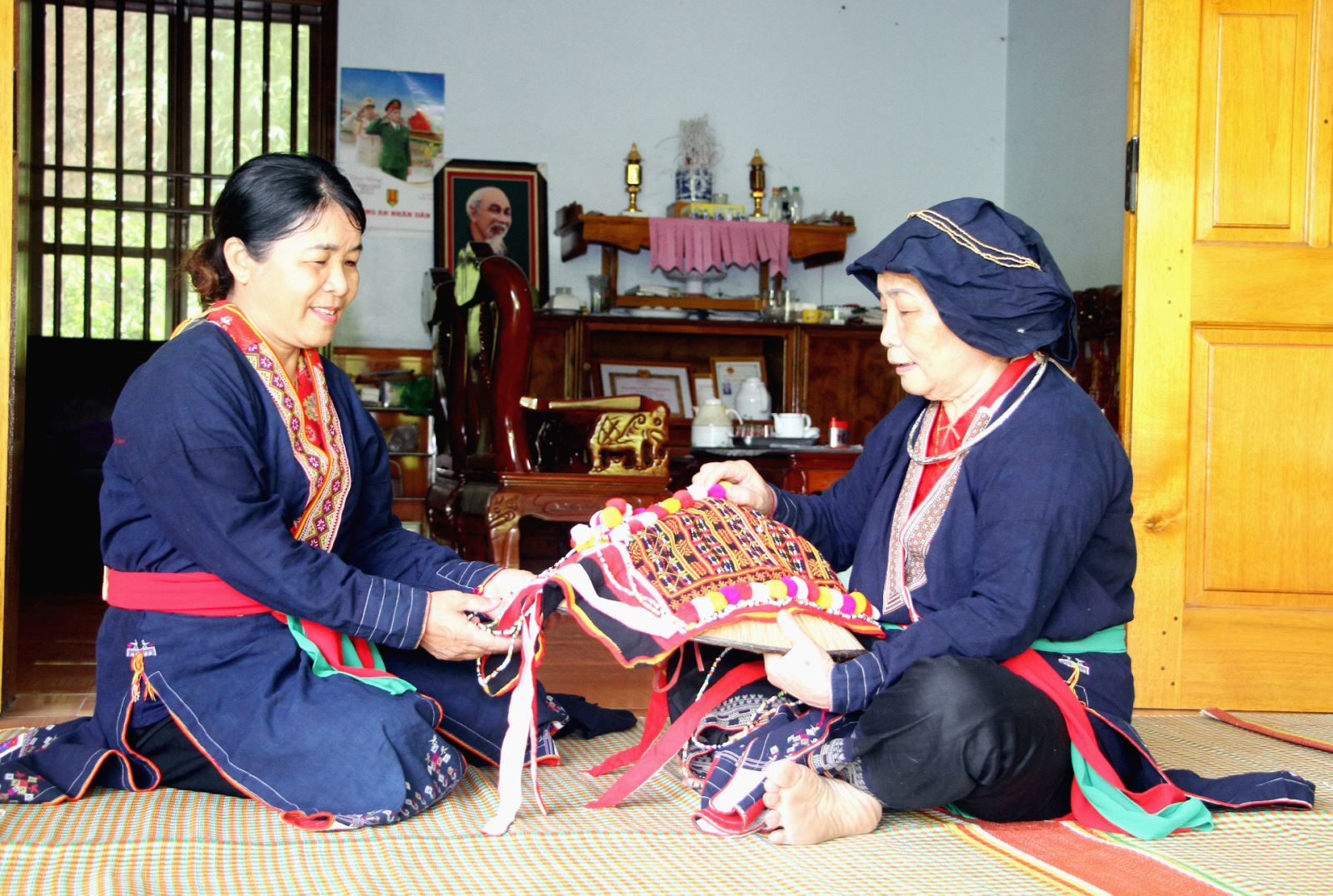  Bà Bàn Thị Hồng (bên phải), Chủ nhiệm CLB hát Pả dung ở xã Phúc Chu (Định Hóa) cùng con gái cả chỉnh sửa trang phục chuẩn bị đi dự Ngày hội Văn hóa dân tộc Dao toàn quốc lần thứ II được tổ chức tại tỉnh Thái Nguyên.