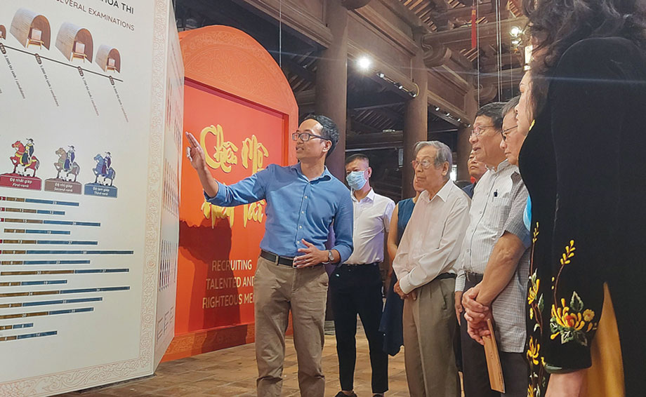 Ông Trương Quốc Toàn (ngoài cùng bên trái) thuyết minh cho du khách tham quan về nội dung trưng bày.