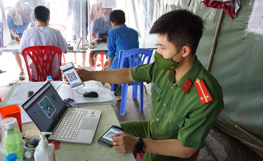  Cán bộ công an quét mã Qr của người dân đi qua chốt kiểm dịch nút giao Tân Long (T.P Thái Nguyên).