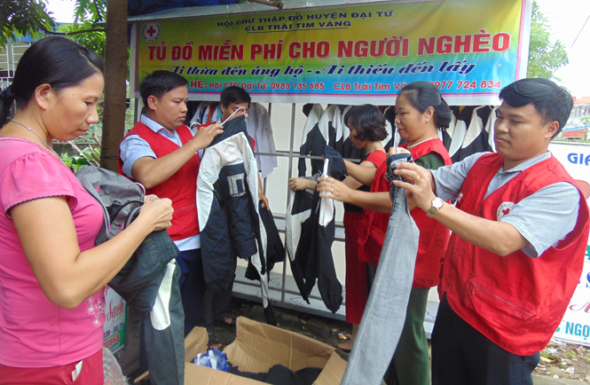 Các thành viên CLB Trái tim vàng đang xếp đặt lại tủ đồ miễn phí dành cho người nghèo.