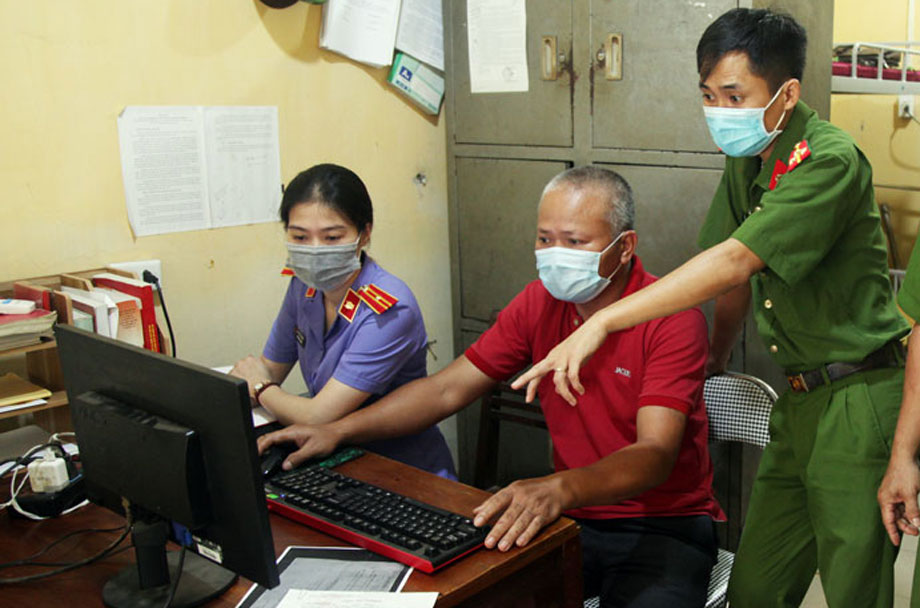 Đối tượng Vũ Văn Hà (áo đỏ) thực hiện lại các thao tác làm giả giấy xét nghiệm COVID-19 trên máy tính cá nhân. (Ảnh T.L)