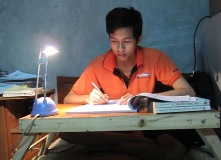  Chiếc bàn gấp được đặt ngay trên giường ngủ bao năm qua là góc học tập của em Hảo.