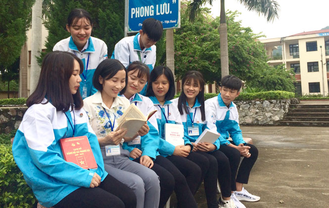  Cô giáo Nguyễn Thị Ngọc Hà (ngồi thứ 2 từ trái sang) cùng các em học sinh lớp 12 trong giờ sinh hoạt ngoại khóa.  