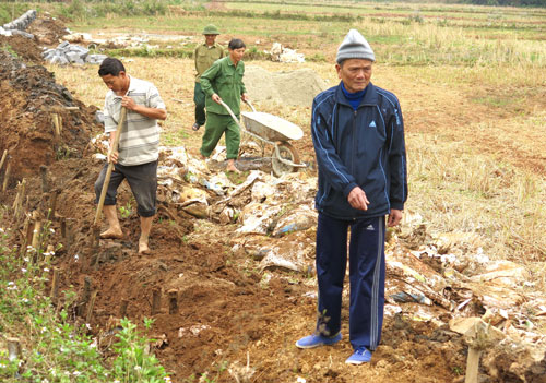  Ông Bùi Đức Long đang cùng bà con trong xóm xây dựng kênh mương cánh đồng Cây Châm. 