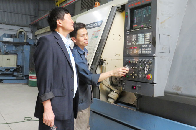   Ông Bùi Xuân Dũng hướng dẫn công nhân vận hành máy tổ hợp gia công cơ khí.