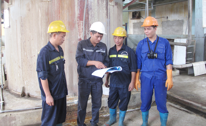  Anh Nguyễn Văn Thuận (người đứng thứ 2 từ trái sang) chỉ đạo các công nhân tại khu vực bơm tuần hoàn axit.