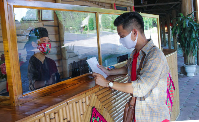  Nhân viên Khu bảo tồn Làng nhà sàn dân tộc sinh thái Thái Hải tuân thủ tốt các quy định phòng, chống dịch khi tiếp đón du khách.