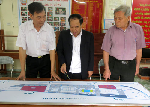  Các đồng chí trong cấp ủy, Chi bộ Khối Đại Cát đang xem bản thiết kế, bàn việc xây dựng tường rào quanh khu thể thao của khối.