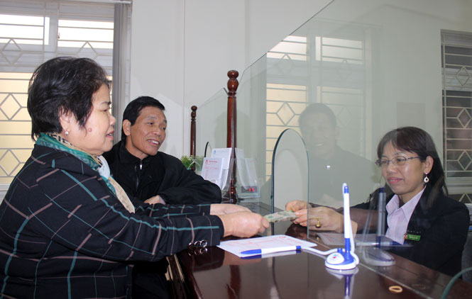  Bà Nguyễn Thị Kim Thoa cùng chồng nộp tiền ủng hộ quý I-2018 cho Chương trình “Cặp lá yêu thương” tại Chi nhánh NHCSXH tỉnh ngày 10-1.