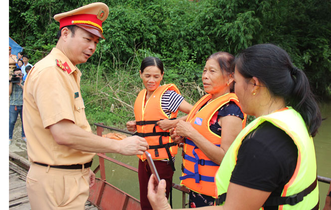  Cấp phát áo phao cho người tham gia giao thông đường thuỷ nội địa tại bến đò Phú Minh, xã Đào Xá, huyện Phú Bình.