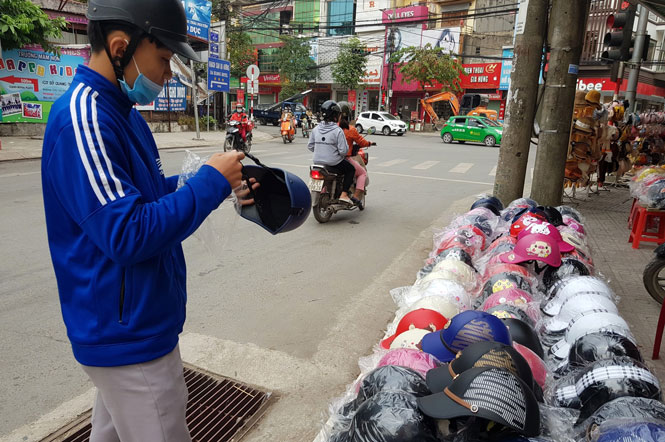  Một nam thanh niên đã mua chiếc mũ bảo hiểm lưỡi trai cầm trên tay với giá 50.000 đồng ở khu vực gần Trường Đại học Sư phạm Thái Nguyên.