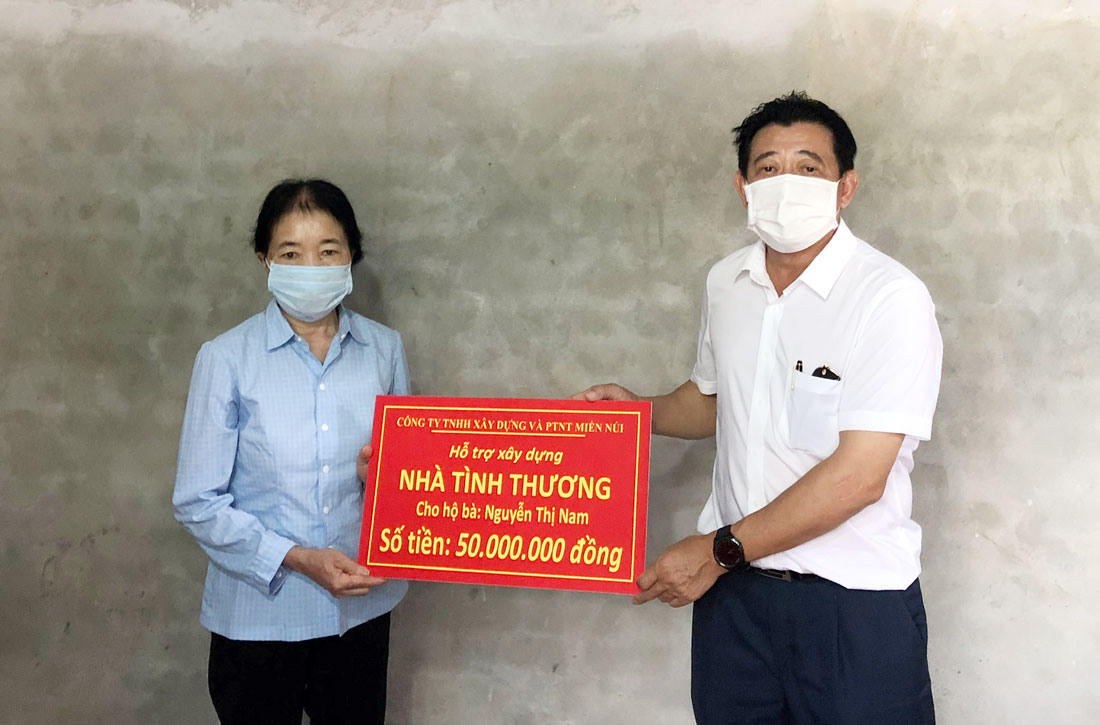  Đại diện Công ty TNHH Xây dựng và Phát triển nông thôn miền núi trao hỗ trợ 50 triệu đồng cho bà Nguyễn Thị Nam.