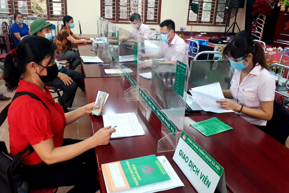  Cán bộ Phòng giao dịch Ngân hàng Chính sách Xã hội huyện Phú Lương thực hiện giao dịch tại UBND xã Yên Lạc.