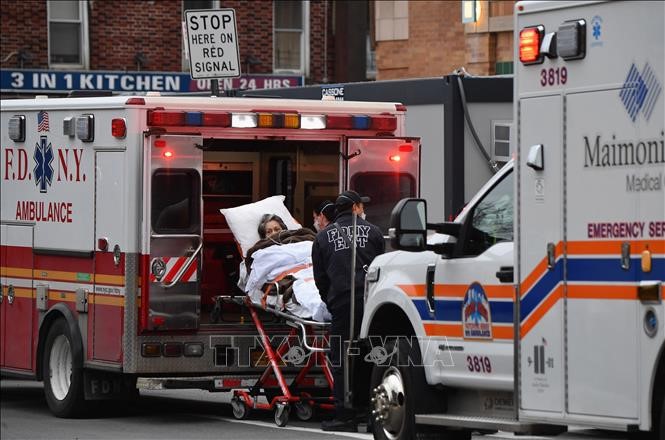  Nhân viên y tế chuyển bệnh nhân COVID-19 tới trung tâm y tế tại New York, Mỹ. Ảnh: AFP/TTXVN