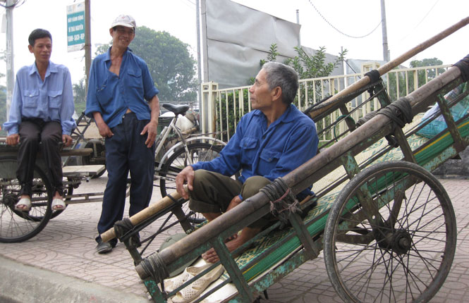  Nhờ hệ thống vỉa hè được làm thấp, có độ vát, anh Trần Văn Thái (người đứng giữa), trú tại tổ 2, phường Trưng Vương (T.P Thái Nguyên) bị khuyết tật bẩm sinh dễ dàng hơn trong việc kéo xe phục vụ khách hàng.