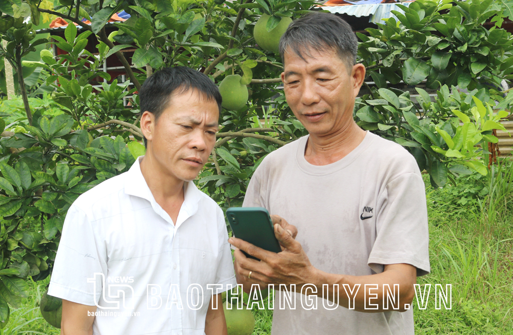  Ông Chu Văn Quân, xóm Cương Lăng, xã Thịnh Đức (bên phải) cài đặt ứng dụng điều hành thiết bị máy móc trên điện thoại.