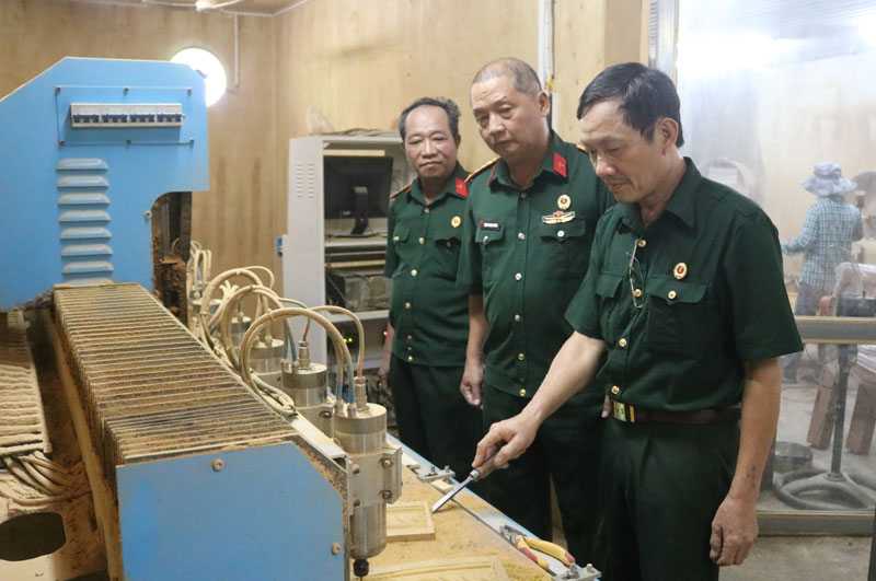  Ông Khúc Văn Xuân (ngoài cùng bên phải) vận hành giàn máy đục vi tính.