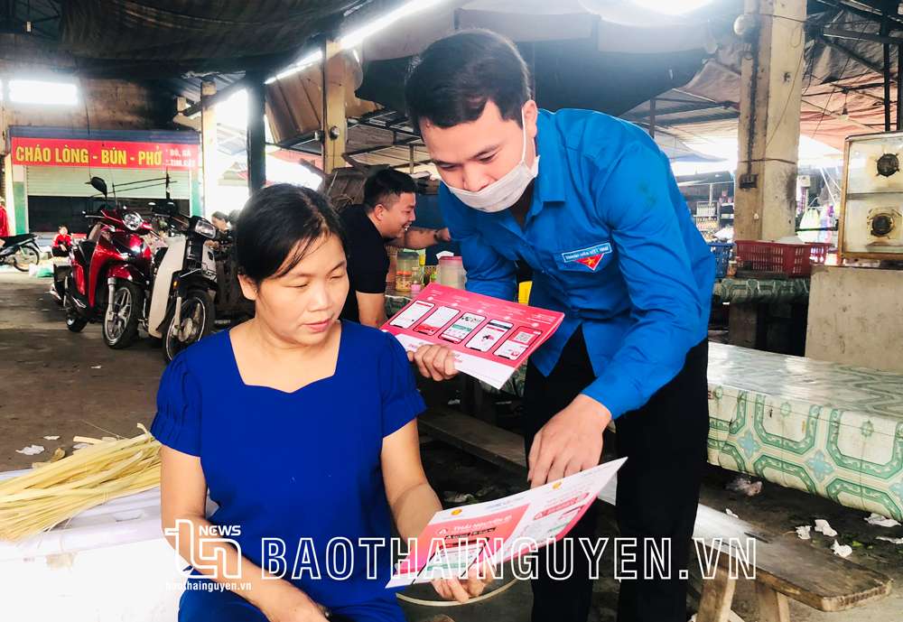 Cán bộ Bảo hiểm xã hội huyện Định Hóa hướng dẫn người dân ở thị trấn Chợ Chu cài đặt ứng dụng VssID.