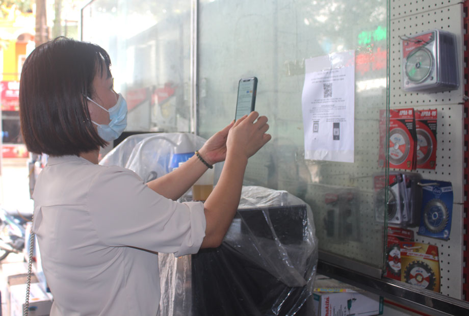  Người dân thực hiện quét mã QR khai báo y tế tại một cửa hàng kinh doanh thuộc phường Mỏ Chè (T.P Sông Công)