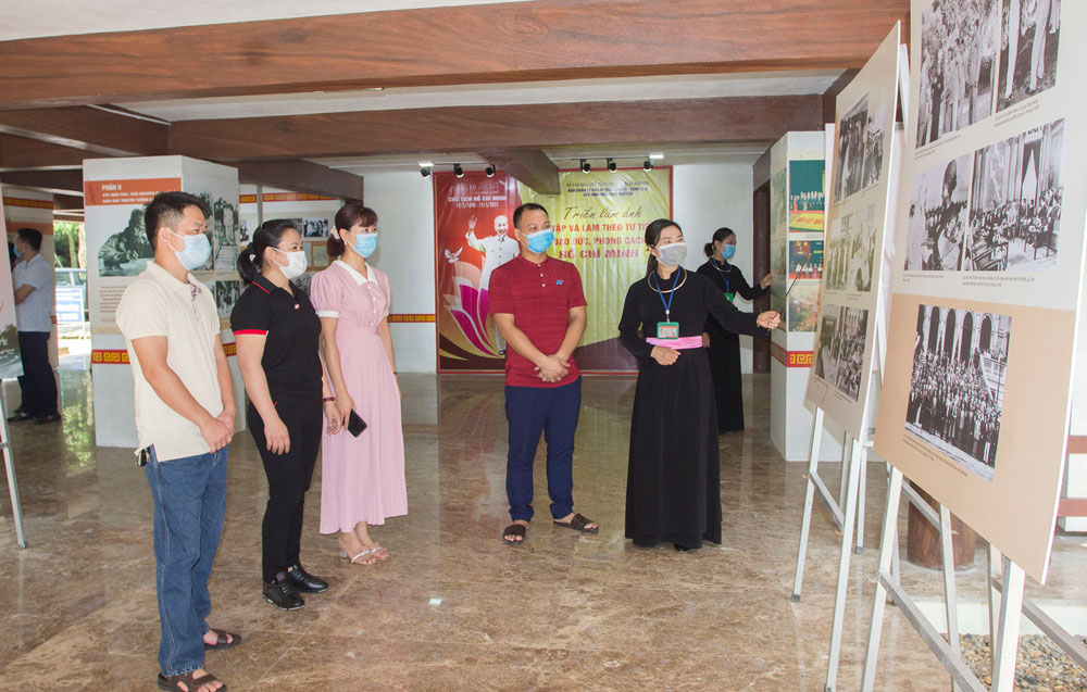 Du khách tham quan gian trưng bày ảnh, tư liệu về Chủ tịch Hồ Chí Minh tại Nhà trưng bày ATK Định Hóa. Ảnh: Thu Hà
