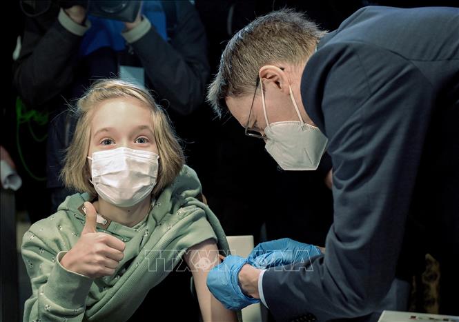  Nhân viên y tế tiêm vaccine ngừa COVID-19 cho em nhỏ 10 tuổi ở Hanover, Đức ngày 17/12/2021. Ảnh: AFP/TTXVN
