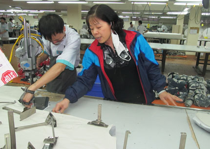  Chị Đường hướng dẫn công nhân cắt mẫu hàng mới