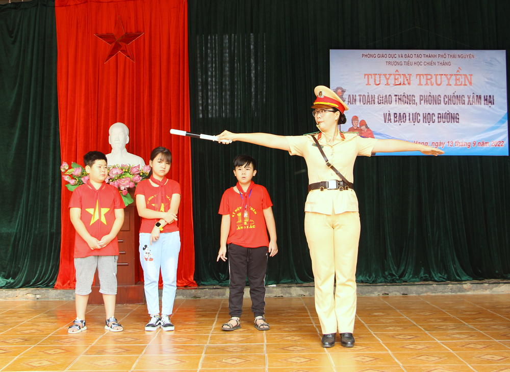  Cán bộ Đội Cảnh sát Giao thông – Trật tự (Công an thành phố) hướng dẫn học sinh thực hiện hiệu lệnh của người điều khiển giao thông.