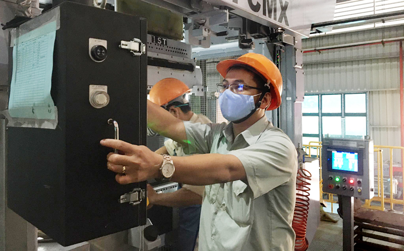  Kỹ sư Nguyễn Thành Đức bên dây chuyền tự động nhúng sơn các chi tiết động cơ Toshiba do anh thiết kế.