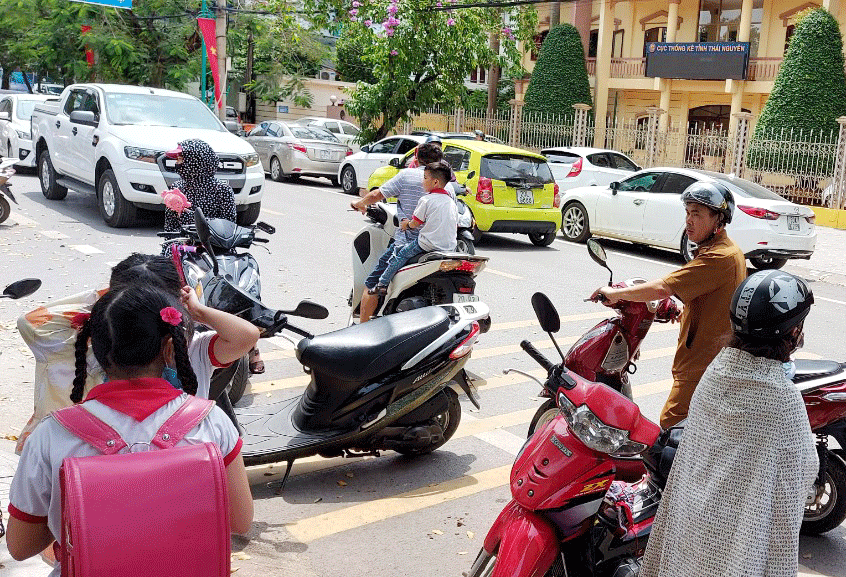  Không ít trường hợp phụ huynh  và  cả con em không đội mũ bảo hiểm khi tham gia giao thông.