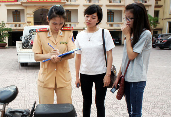  Cán bộ Đội Cảnh sát giao thông, Công an T.P Thái Nguyên lập biên bản tạm giữ phương tiện của người điều khiển xe đạp điện không đội mũ bảo hiểm.