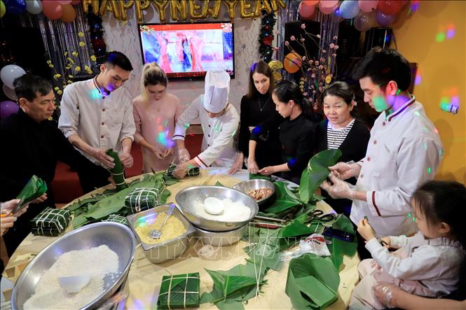  Trước thềm năm mới Nhâm Dần 2022, các cô gái Nga Iumzhana Daneeva và Marina Karabaeva có trải nghiệm thú vị cùng tham gia gói bánh chưng, bánh tét truyền thống của Việt Nam. Ảnh: Trần Hiếu - PV TTXVN tại Nga