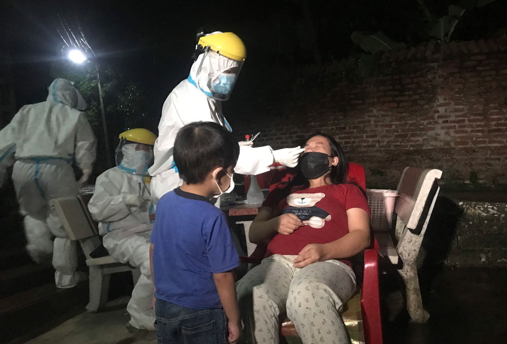  Lực lượng chức năng lấy mẫu xét nghiệm ngay trong đêm các trường hợp liên quan đến 2 ca bệnh tại phường Cam Giá.