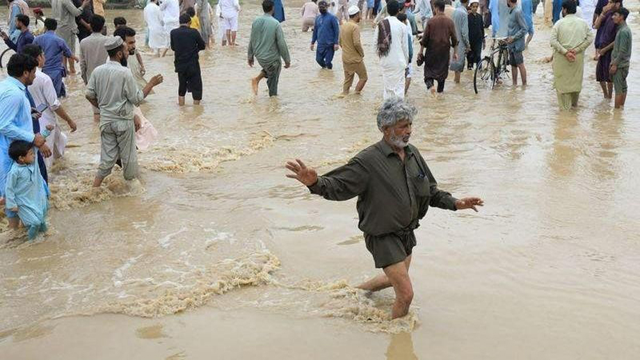  Người dân di chuyển trên con đường bị ngập tại Charsadda, Pakistan. (Ảnh: Reuters)