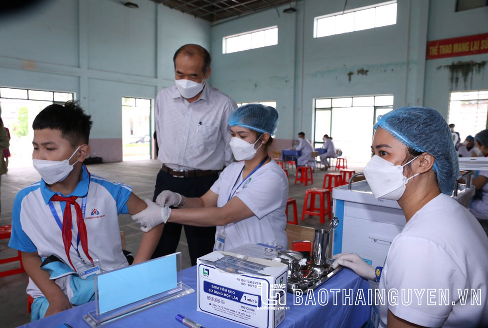  Cán bộ Trung tâm Y tế TP. Thái Nguyên tiêm vắc-xin phòng COVID-19 cho học sinh Trường THCS Chu Văn An dưới sự giám sát của lãnh đạo Trung tâm Kiểm soát bệnh tật tỉnh.