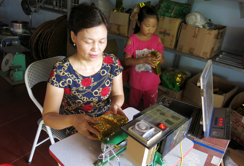  Đóng gói chè bằng máy hút chân không ở Tổ hợp tác trồng và chế biến chè theo tiêu chuẩn VietGAP Kim Thoa, xóm Cây Thị.